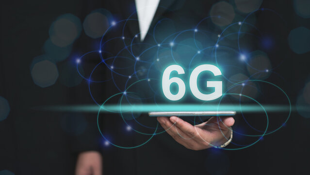 Hand holding a smartphone with glowing "6G" text and futuristic network connections, symbolizing advanced technology. Concept of innovation, connectivity, and digital transformation.