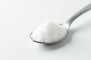 Spoonful of white sugar against white backdrop, spoon, texture