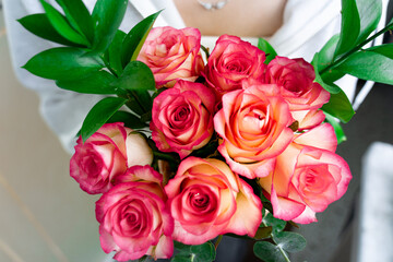 girl holding a bouquet of pink roses in her hands