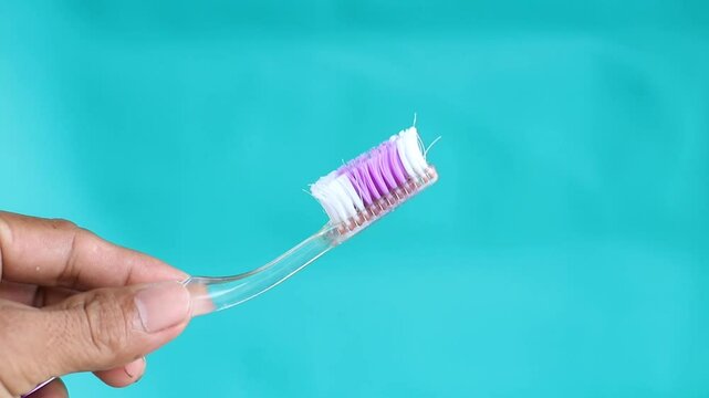 Someone's hand is holding an old toothbrush that is no longer suitable for use
