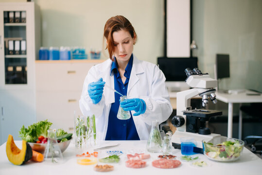 Scientist testing food samples in lab with microscope, vegetables, and meat for safety, nutrition, and biotechnology