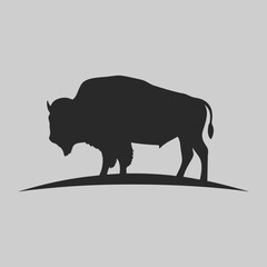 Majestic American Bison Silhouette on Gray Background simple elegant black vector illustration of wild animal on a hill
