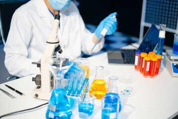 male scientist working with micro pipettes analyzing biochemical samples, advanced science chemical...
