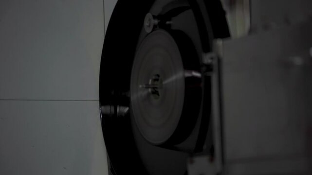 M&aacute;quina antigua de revelado de pel&iacute;cula, procesadora de f&iacute;lmico con engranajes y rodillos. Maquinaria industrial en acci&oacute;n, equipo de laboratorio de cine cl&aacute;sico.