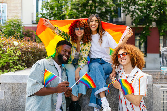 Group of diverse friends celebrating lgbt pride month with rainbow flags