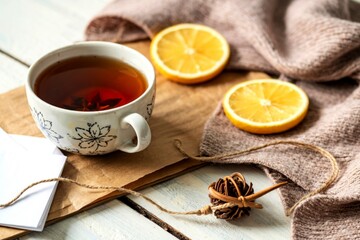 Cup of tea with scarf on a wooden background