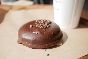 Delicious chocolate-coated dessert on a wooden table