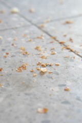 Crumbs scattered on a polished floor in a busy indoor space