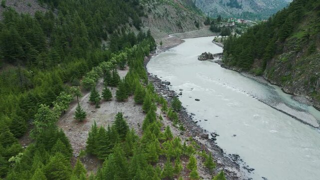 4K Bird's eye view of Chenab river flowing during the summer season as seen near Mini Manali in Lahaul, Himachal Pradesh, India. Summer travel background. Nature landscape.