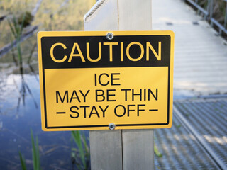 Thin Ice caution sign at Cheam Lake Wetlands Regional Park during a spring season in Rosedale, Fraser Valley, British Columbia, Canada