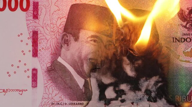 close up on 100 thousand rupiah banknote burned with green background.
