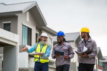 Three men in construction gear are walking down a street, one of them holding a tablet. Scene is professional and focused, as the men are likely discussing plans or progress on a construction project