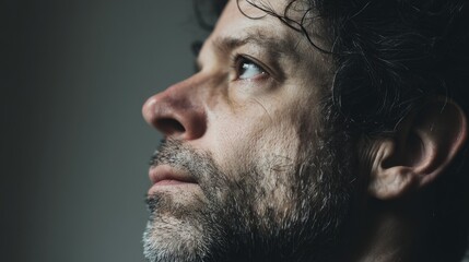Obraz premium A man's intense gaze, lost in thought; quiet determination in a moment of focus. 