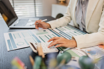 working in the office with a lot of paper work, businessman is checking marketing data, e an...