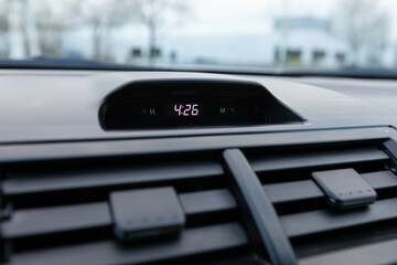 Digital dashboard clock showing time in a 2013 Japanese sedan car, with surrounding vents and soft...