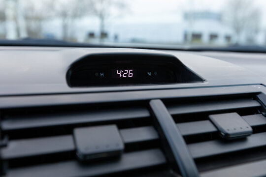Digital dashboard clock showing time in a 2013 Japanese sedan car, with surrounding vents and soft dashboard surface details