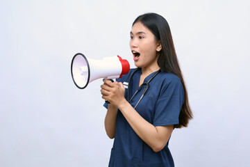Young Asian woman doctor on white studio background speaking talking in loudspeaker. Make announcement in speaker. Medicine, attention, healthcare concept.Holding megaphone