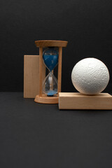 Still life with wooden blocks, hourglass and a a plastic foam ball	