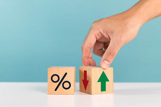 Financial, stocks, interest rate and GDP percent change. A man hand flipping wood block with Increasing percentage sign for interest rate ,ranking ,financial stocks and GDP percent change