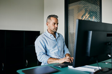 Focused Business Professional Working At Desk In Modern Office Space