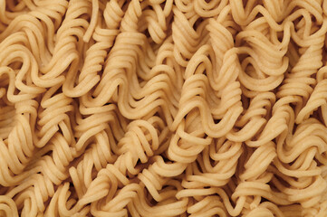 Suchy surowy makaron błyskawiczny w kostce z bliska, kadr wypelniony