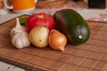 Fresh vegetables on the table. garlic, tomato, zucchini onion, marrow, potatoes, cucumber.