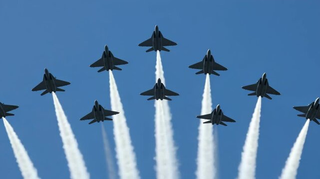 Spectators watch as fighter jets fly in formation, creating impressive vapor trails