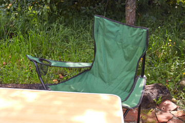 Set of folding furniture for camping, table and chair, summer nature of wild meadow