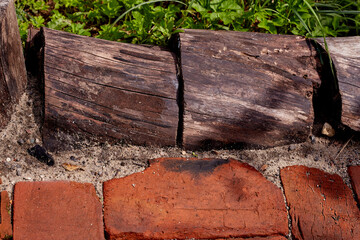 The texture is red old brick, tree stumps and green grass. rustic style. the patio. recreation area.