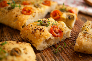 Authentic Italian focaccia with tomatoes and green olives.