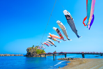 糸魚川市能生の弁天岩と青い海、空に舞う鯉のぼり｜5月の風景