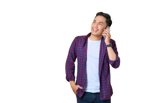 Smiling young Asian man in plaid shirt talking on mobile phone and looking away at copy space isolated on transparent background