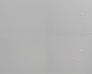 A light grey wall shows slight texture and patchy peeling paint on the right side, suggesting surface damage or moisture issues.