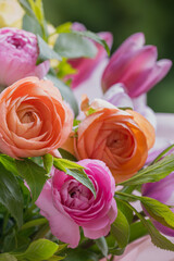 Ranunculus spring bouquet. Beautiful multi colored fresh flower arrangement. Birthday bouquet made of ranunculus photographed outdoors.