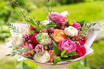 Spring mixed bouquet. Beautiful pastel colored fresh flowers arrangement. Birthday bouquet made of ranunculus photographed outdoors.