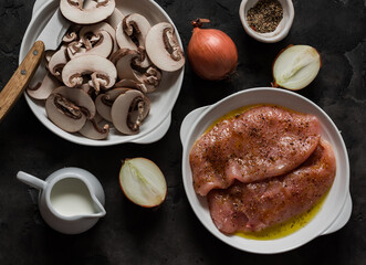 Ingredients for cooking chicken breast with mushroom cream sauce on a dark background, top view