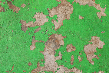 Green concrete wall with old shabby coating. Smooth stone floor with remains of old paint. Grained concrete floor with green peeling paint. Spotted background, texture. Surface with greenish tint