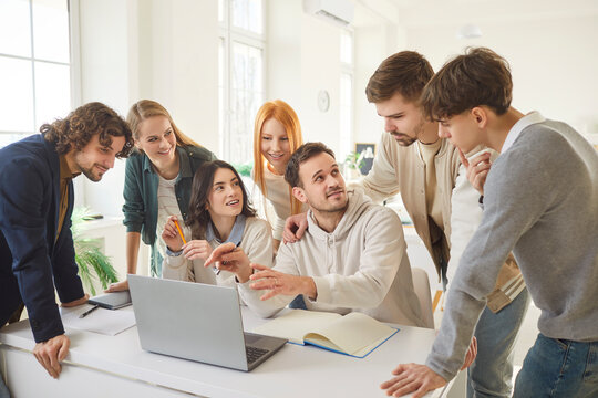 Successful team of young college planning, friends students brainstorming together working online doing study project in university, library, office using laptop, learning unity, making new report