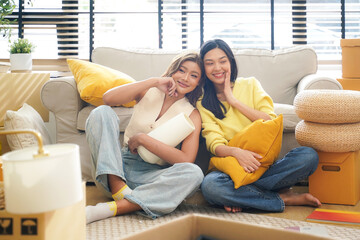 Young women and friend help moving home while packing boxes together and happy in new home.  Asia women investment real estate for living with family.  Investment and Family Concept