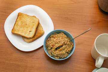 dining table set with a plate of toasts and a bowl of guacamole, ready for a casual and delicious meal