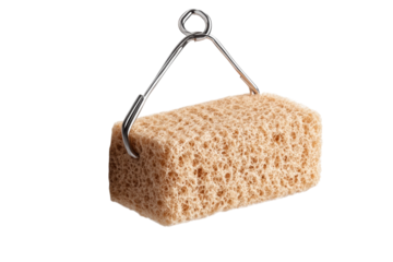 A close up of a natural sea sponge hanging on a metal hook against a black background showing on transparent background
