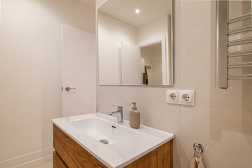 Modern bathroom vanity with white ceramic sink, wood drawers and wall-mounted mirror