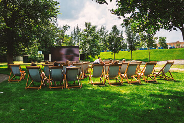 Summer Movie Night Under the Stars Outdoor Cinema Deck Chairs on Green Lawn Trees