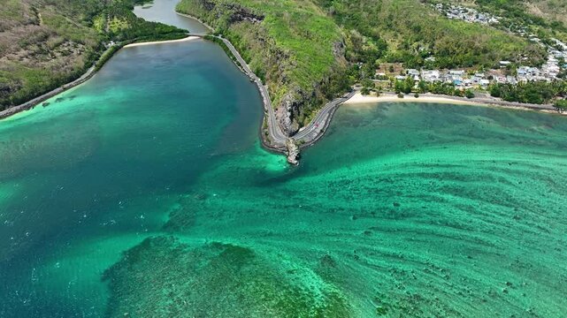 Aerial view transitions from swirling turquoise ocean and reef textures to the iconic Maconde Viewpoint and coastal curve in southern Mauritius
