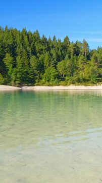 Idyllic lakeside landscape at Urisee in Reutte Tirol featuring turquoise water, alpine hills, and relaxing untouched nature