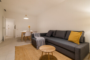 Bright living room with modern gray sectional sofa and mustard accent pillow in neutral tones