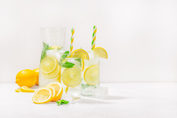 Summer refreshing lemonade drink cocktail with ice, sliced lemon and mint, summer concept. copy...