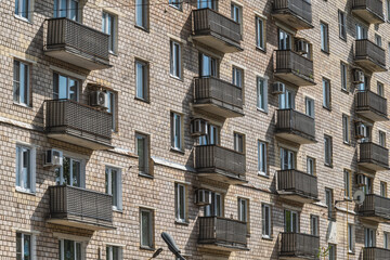Pattern of balconies on a brick wall of a house. Architectural environment.