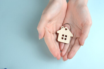 Keychain in the shape of a house in the palm of your hand.