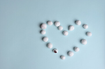 Heart of cranberries in sugar on a blue background.